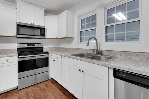 a kitchen with granite countertop a sink stainless steel appliances and counter space
