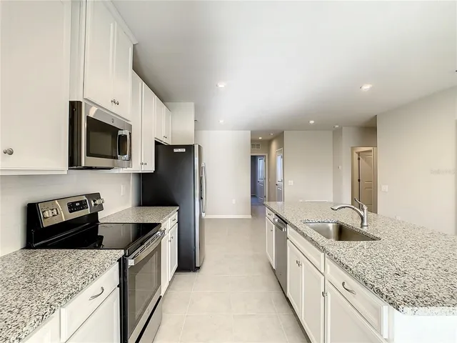 a kitchen with granite countertop a sink and steel appliances