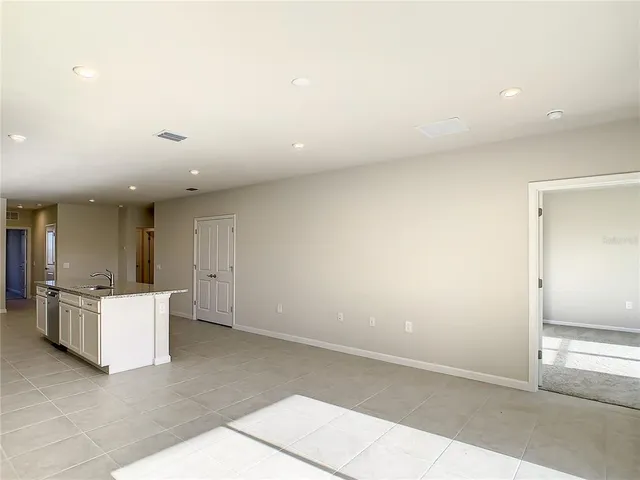 an empty room with kitchen and window