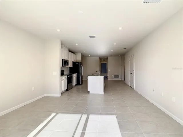 a view of a kitchen with a refrigerator and a living room