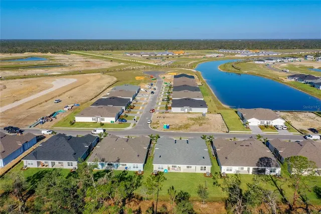 an aerial view of multiple houses with a yard