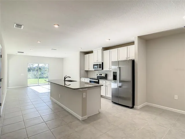 a kitchen with stainless steel appliances a refrigerator sink and cabinets