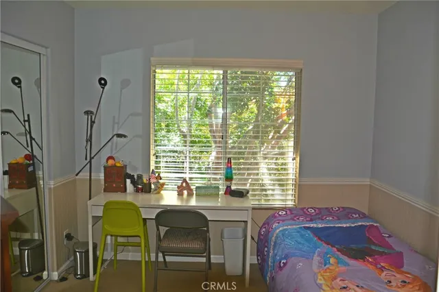 a bed sitting in a bedroom next to a window