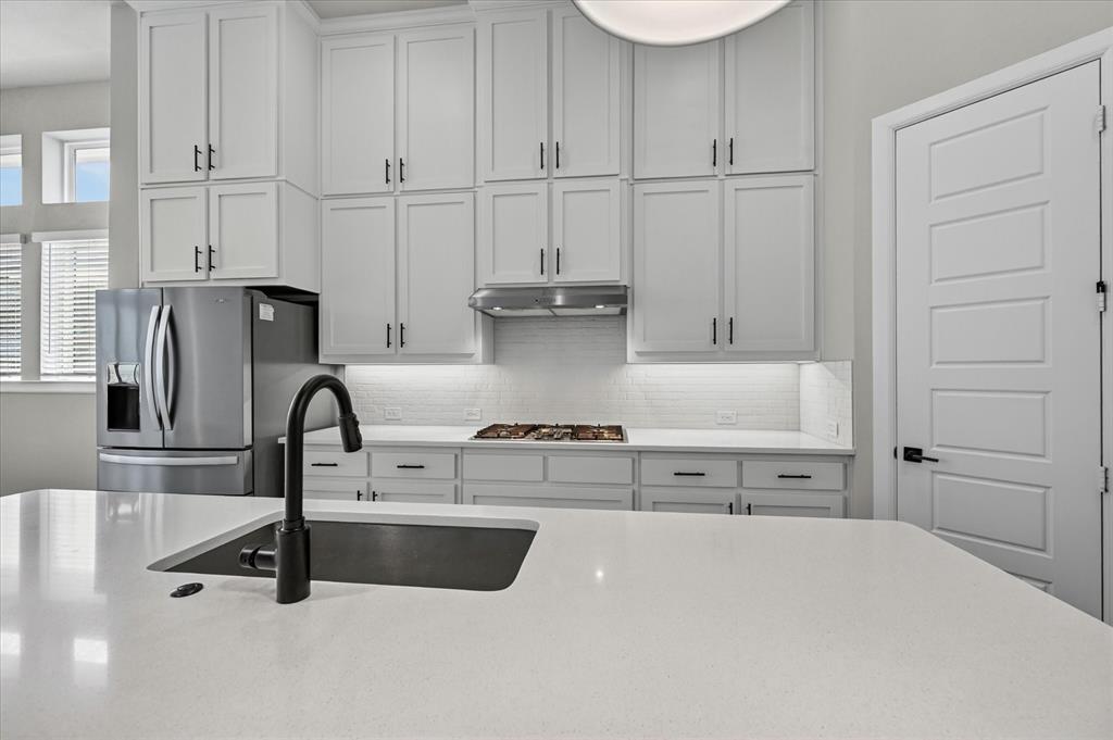 2237 Pika Road Northlake, TX 76247 - Photo 11 of 37 Kitchen featuring white shaker cabinetry, stainless steel appliances, a gas cooktop, and a white subway tile backsplash