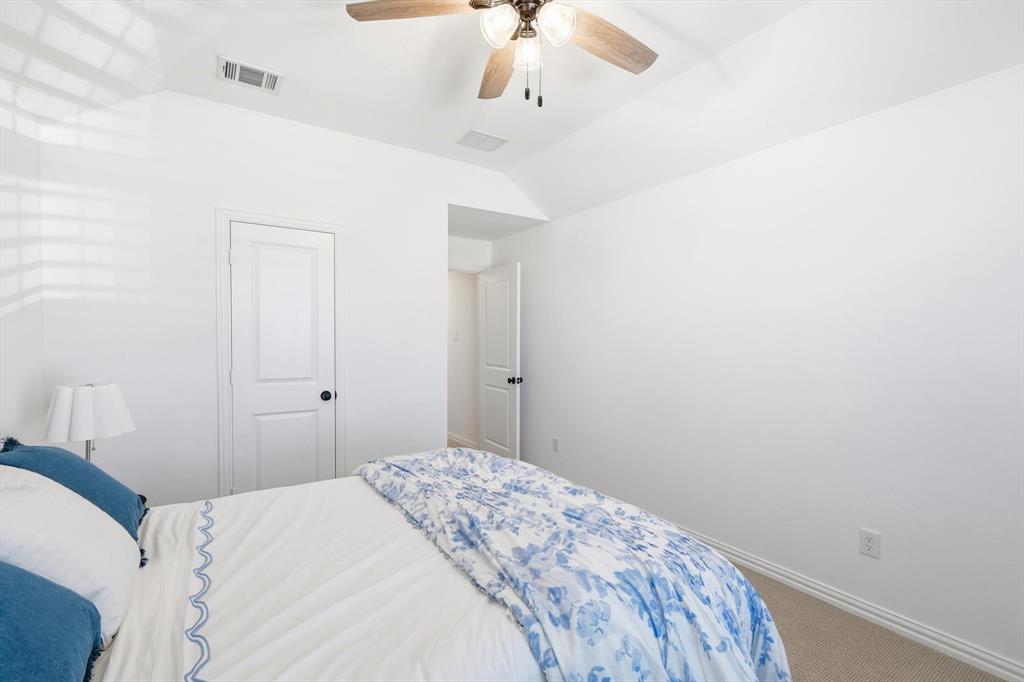 2171 Cloverfern Way Haslet, TX 76052 - Photo 26 of 38 a bedroom with a bed and a chandelier fan