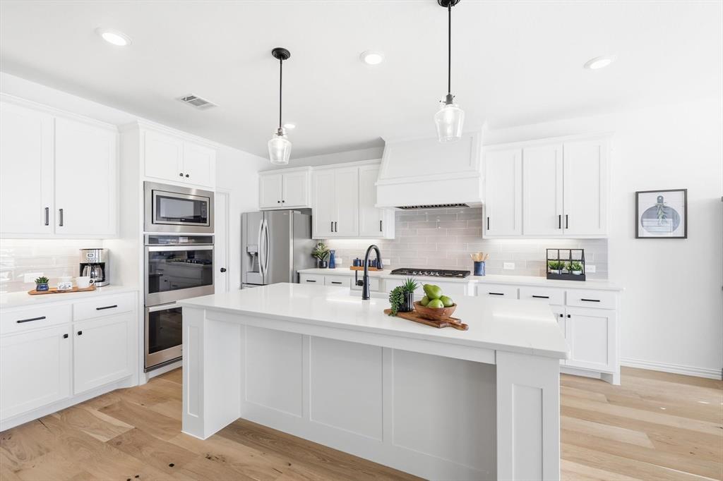 2171 Cloverfern Way Haslet, TX 76052 - Photo 6 of 38 a kitchen with stainless steel appliances granite countertop a sink refrigerator and cabinets