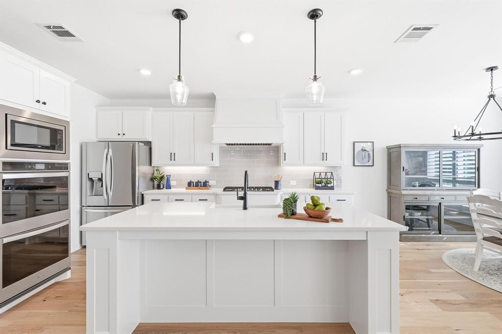 2171 Cloverfern Way Haslet, TX 76052 - Photo 7 of 38 a kitchen with stainless steel appliances kitchen island granite countertop a sink stove and refrigerator