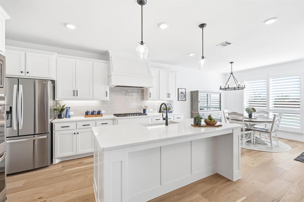 2171 Cloverfern Way Haslet, TX 76052 - Photo 8 of 38 a kitchen with white cabinets and stainless steel appliances
