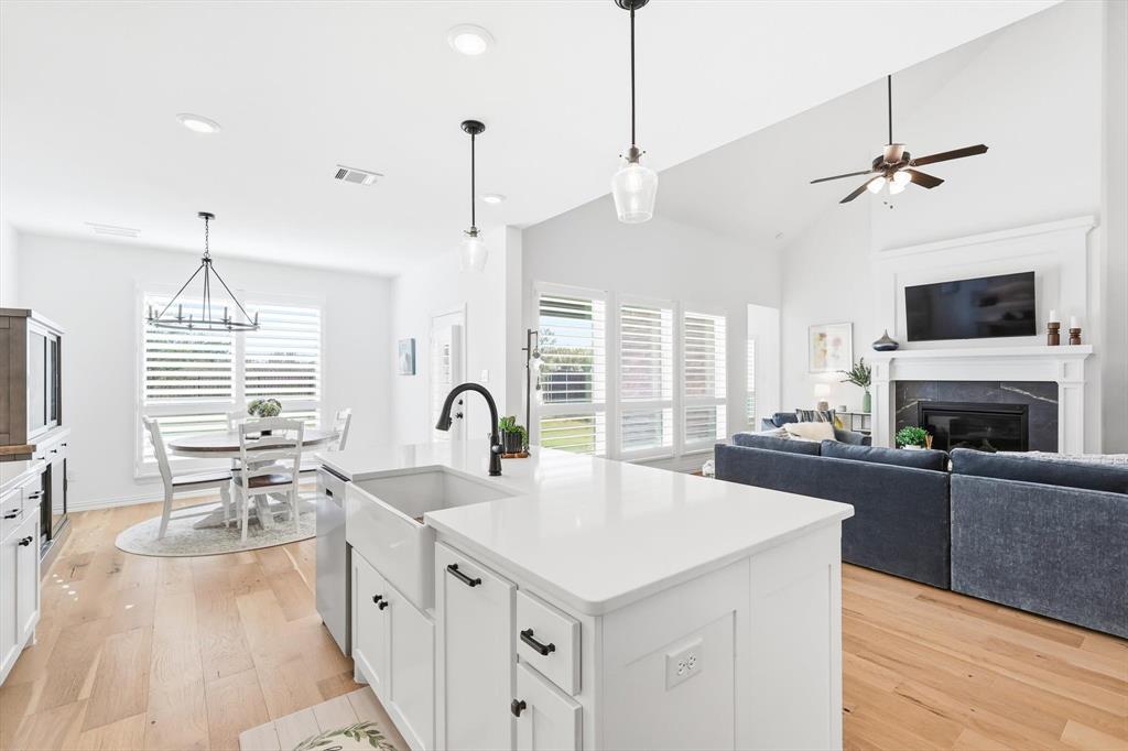 2171 Cloverfern Way Haslet, TX 76052 - Photo 9 of 38 a kitchen with a stove a sink a kitchen island with wooden cabinets and wooden floor