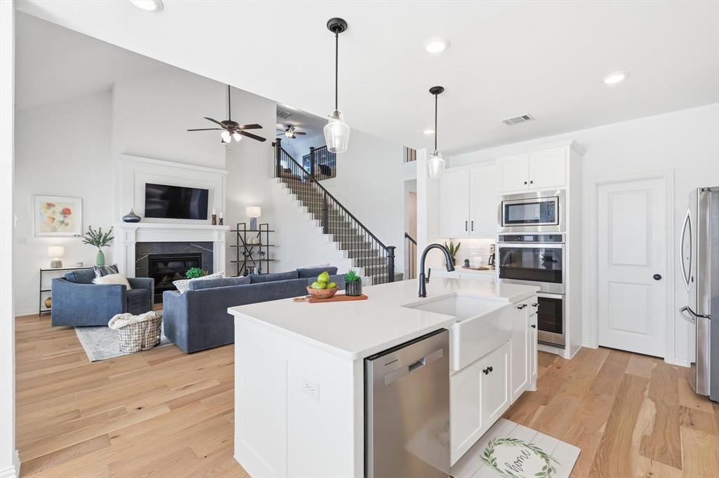 2171 Cloverfern Way Haslet, TX 76052 - Photo 10 of 38 a open kitchen with a sink a fireplace and a chandelier