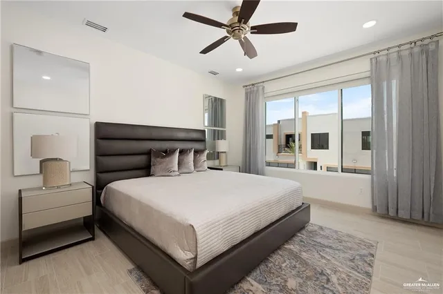a bedroom with a large bed and a chandelier fan