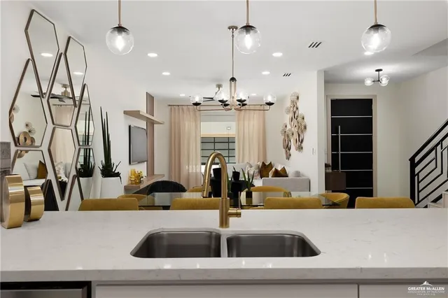 a kitchen view with granite countertop a sink and a large mirror