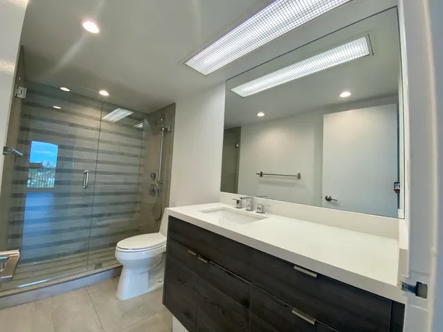 a bathroom with a double vanity sink toilet and shower