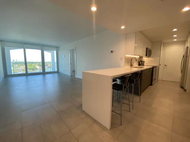 a kitchen with a sink a stove cabinets and wooden floor