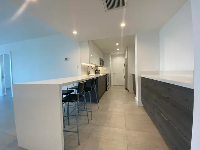 a large white kitchen with a sink and cabinets