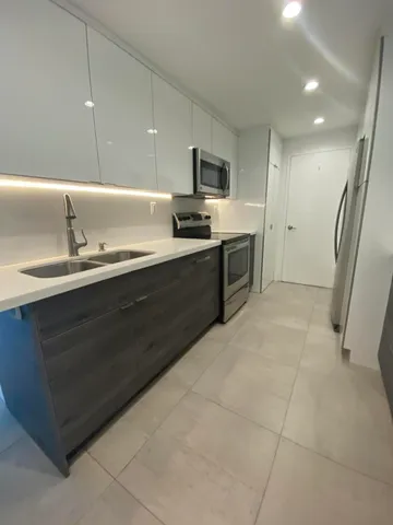 a kitchen with a sink stainless steel appliances and cabinets