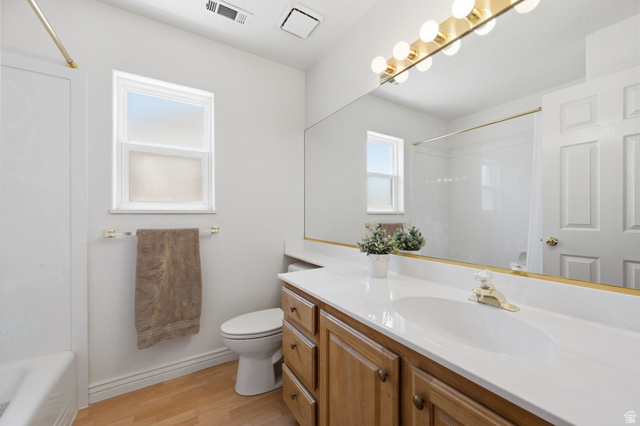 805 South River Road, Unit 70 St. George, UT 84790 - Photo 24 of 38 Bathroom featuring a wood-finish vanity with a white countertop and integrated sink, full-width mirror, and brass-tone vanity lighting