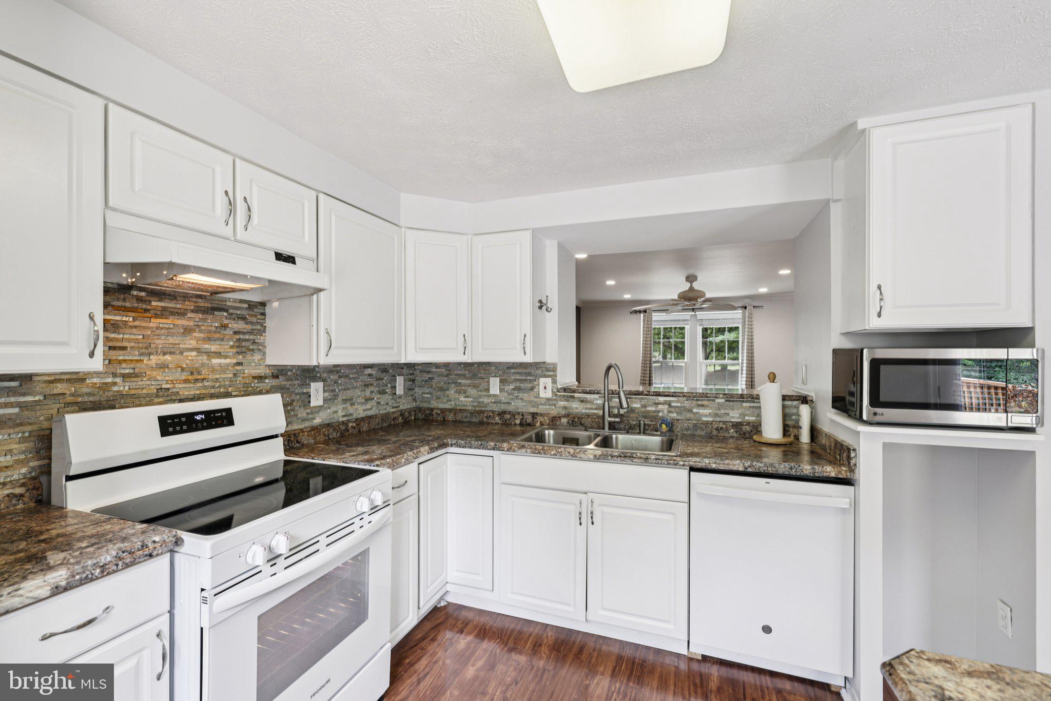 7813 Paddock Way Windsor Mill, MD 21244 - Photo 10 of 30 a kitchen with granite countertop white cabinets and white appliances