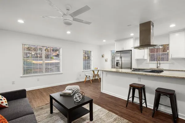 a living room with stainless steel appliances kitchen island furniture and a table