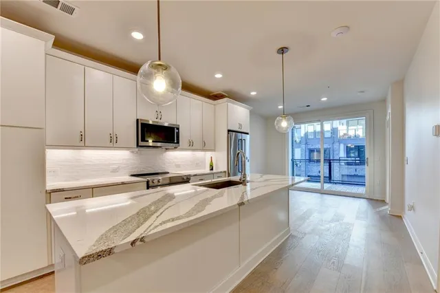 a kitchen with a sink and a stove top oven with wooden floor