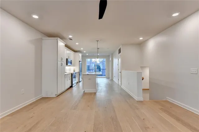 a view of a big room with wooden floor and windows