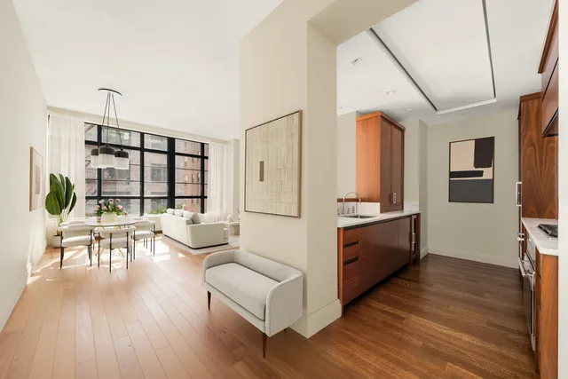 a living room with furniture a large window and wooden floor