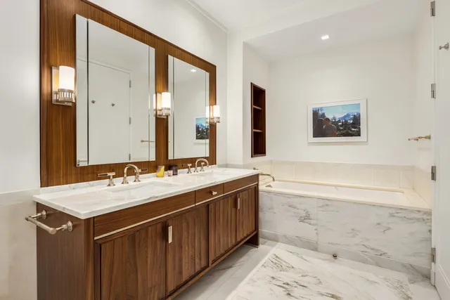 a bathroom with a tub sink and mirror