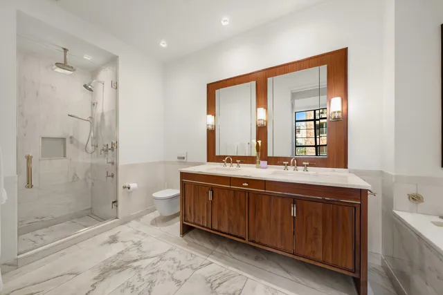 a spacious bathroom with a double vanity sink mirror and shower