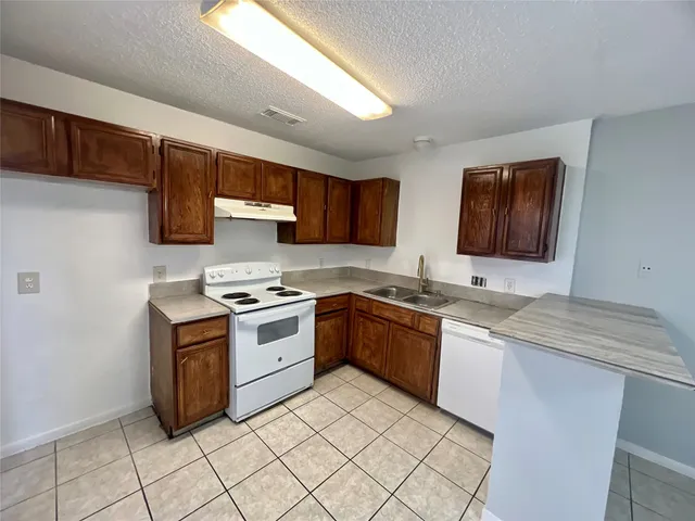 a kitchen with stainless steel appliances granite countertop a stove sink and cabinets
