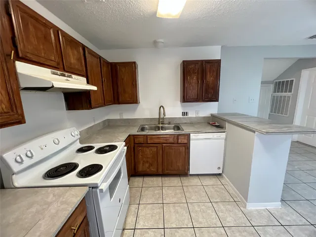 a kitchen with a stove sink and cabinets
