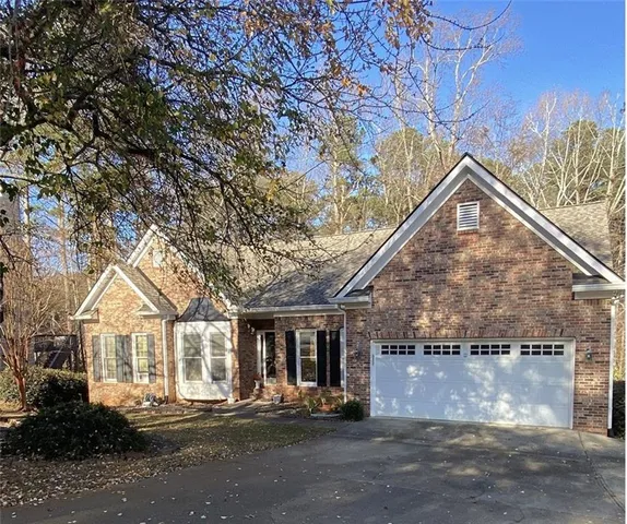a view of a house next to a yard and trees