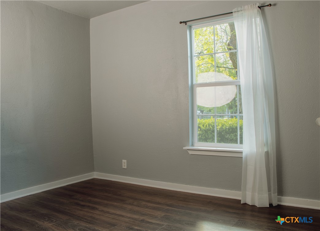 1407 South 7th Street Temple, TX 76504 - Photo 20 of 36 an empty room with wooden floor and windows