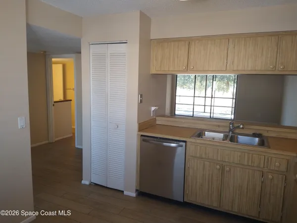 a kitchen with white cabinets a sink and a window