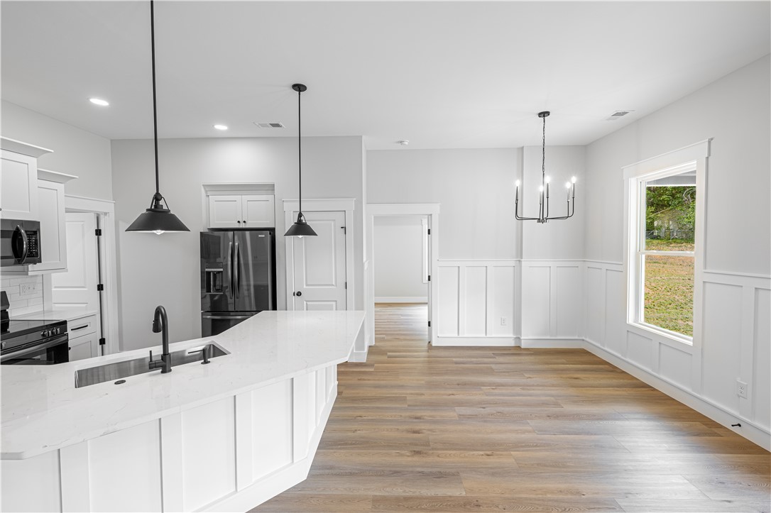 105 Leon Drive Anderson, SC 29621 - Photo 14 of 46 This bright kitchen and dining area features modern fixtures and ample space for comfortable living.