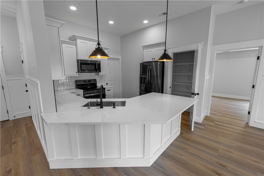 105 Leon Drive Anderson, SC 29621 - Photo 16 of 46 This modern kitchen features a breakfast bar, sleek appliances, and durable flooring.