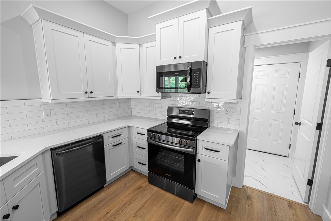 105 Leon Drive Anderson, SC 29621 - Photo 41 of 46 This modern kitchen features pristine white cabinetry and sleek stainless steel appliances.