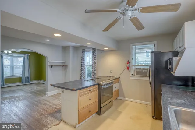 a kitchen with stainless steel appliances granite countertop a refrigerator a sink and a stove