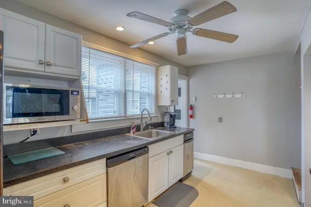 a kitchen with granite countertop a sink stainless steel appliances and cabinets