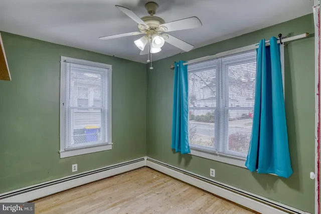 a view of empty room with window and fan