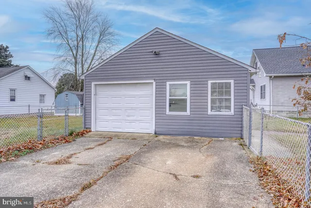 a view of a house with a small yard and a large tree