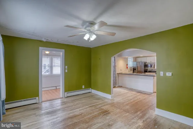a view of a livingroom with wooden floor and a ceiling fan