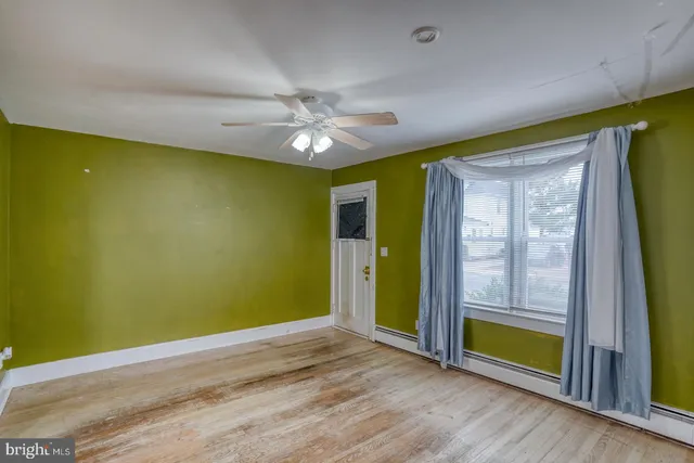 a view of room with window ceiling fan and hardwood floor