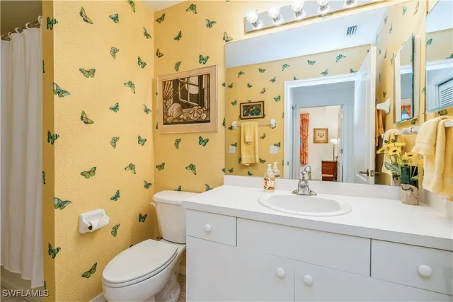 a bathroom with a sink a toilet and shower curtain