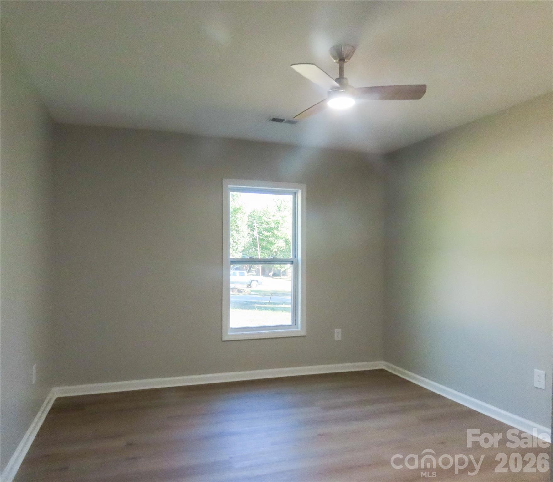 433 Clinton Avenue Lancaster, SC 29720 - Photo 19 of 28 an empty room with wooden floor and windows
