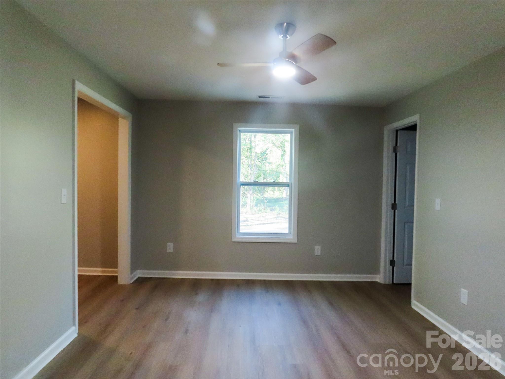 433 Clinton Avenue Lancaster, SC 29720 - Photo 22 of 28 a view of an empty room with wooden floor and a window