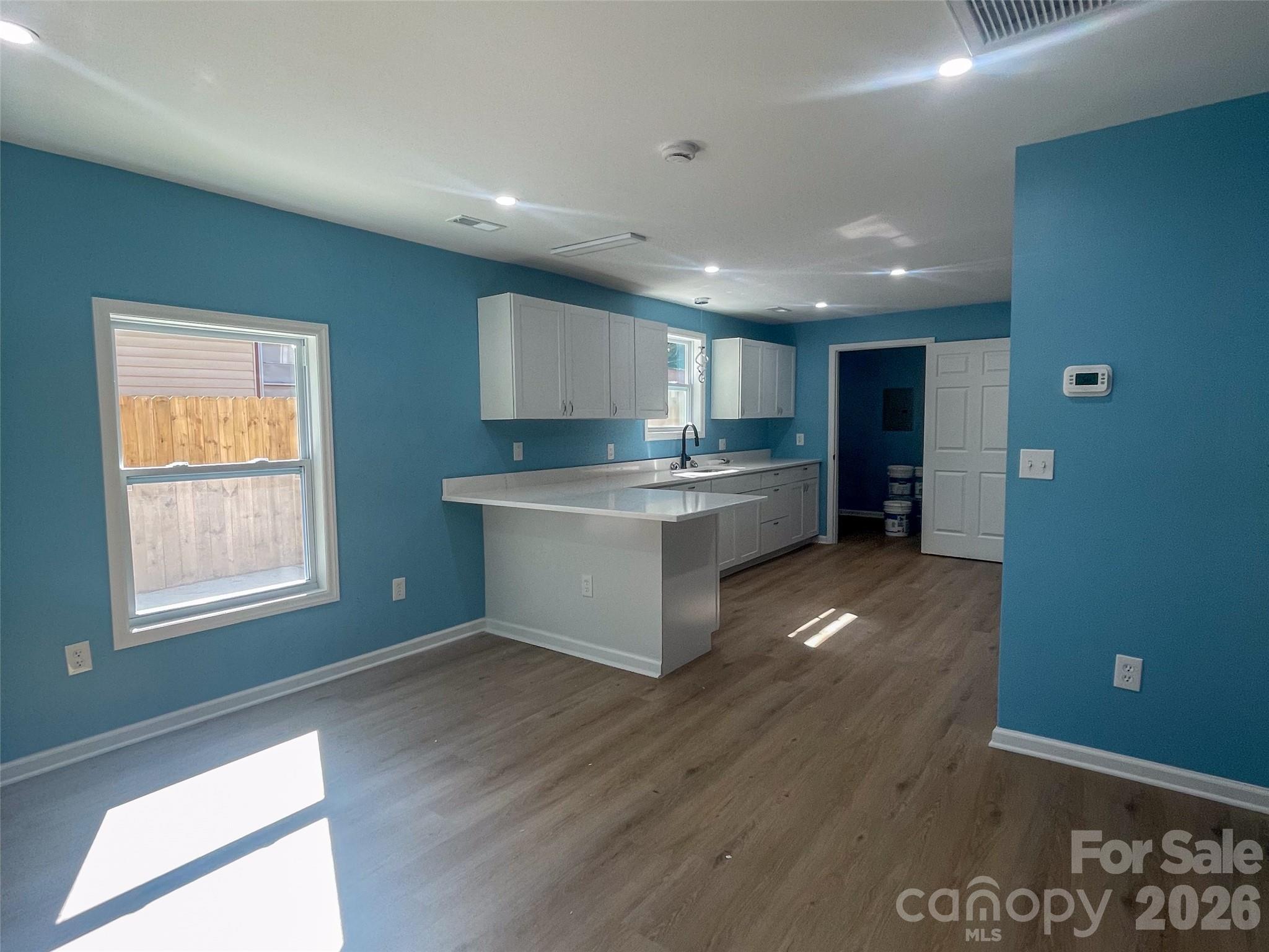 433 Clinton Avenue Lancaster, SC 29720 - Photo 10 of 28 a kitchen with stainless steel appliances granite countertop a stove a refrigerator a sink a microwave oven with wooden floor and cabinets