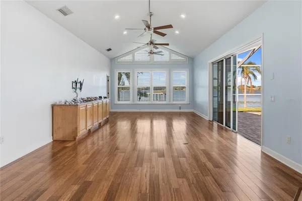 a view of a hallway with wooden floor and a living room