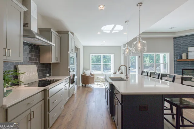 a kitchen with granite countertop a sink a counter space appliances and cabinets
