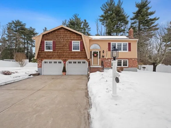 a front view of a house with a yard covered in snow