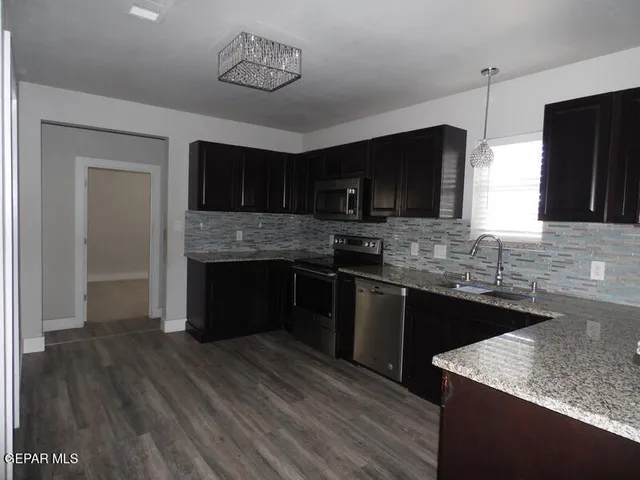 a kitchen with a sink stove top oven and refrigerator